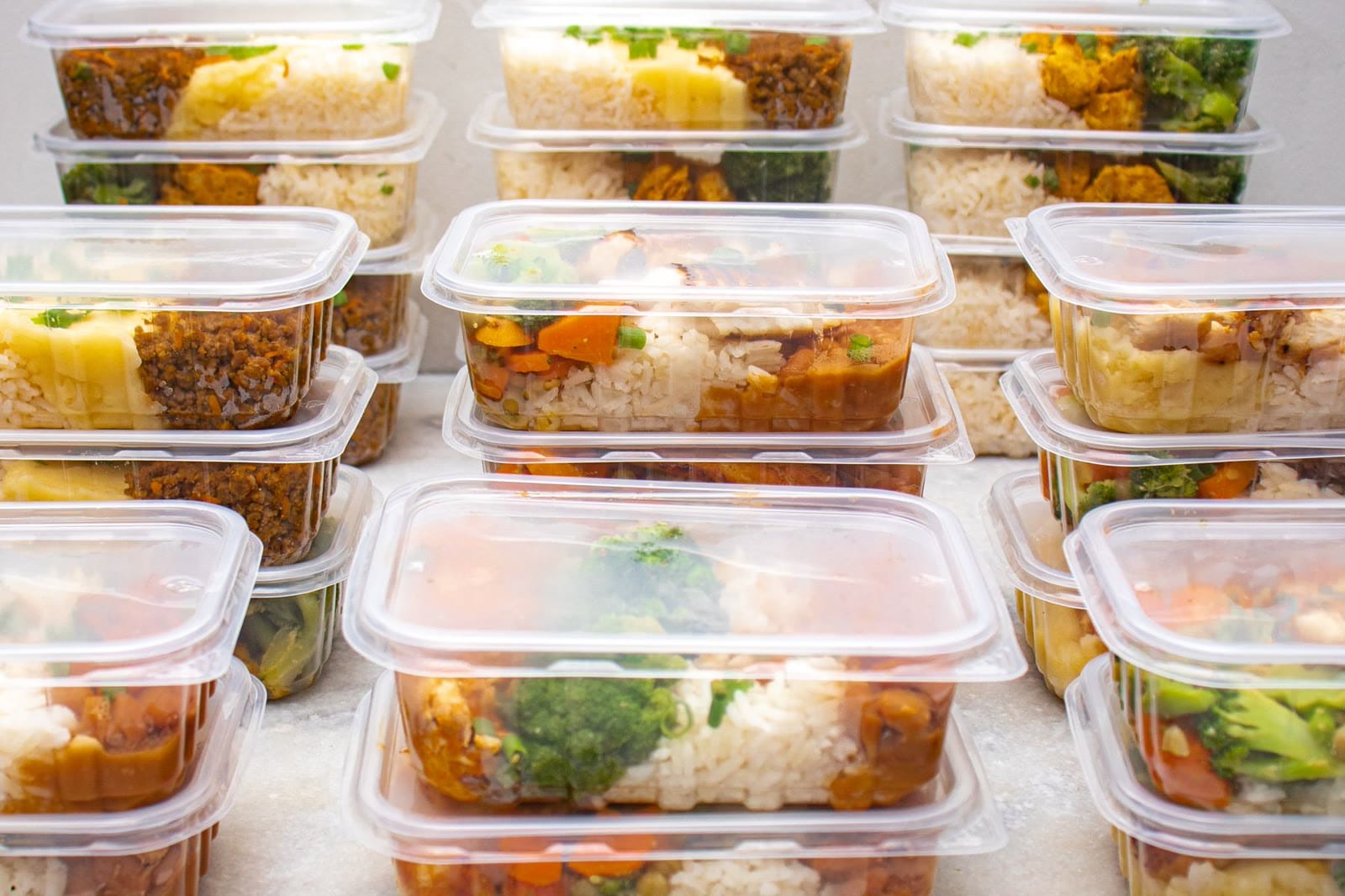Cinco marmitas de vidro organizadas com arroz, legumes, fritada e ovos cozidos
